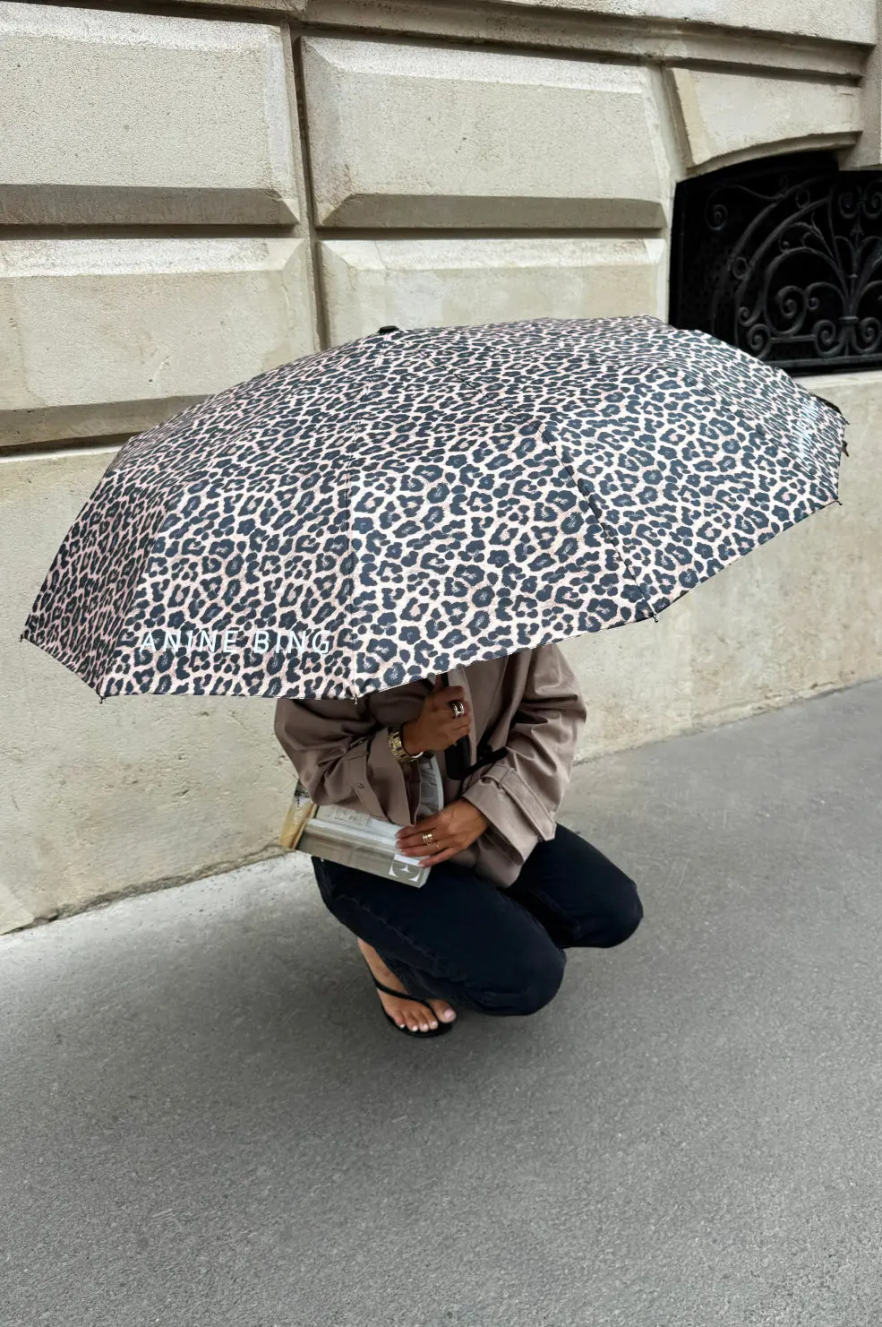 A model crouching under a leopard print umbrella, Anine Bing