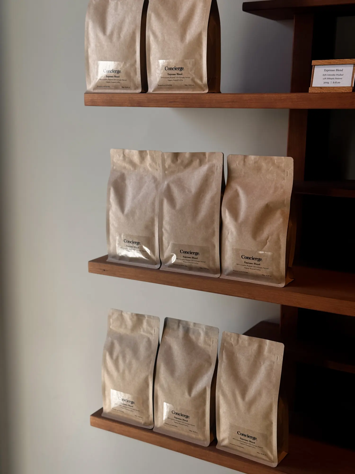 Bags of Concierge Coffee beans on wooden shelves
