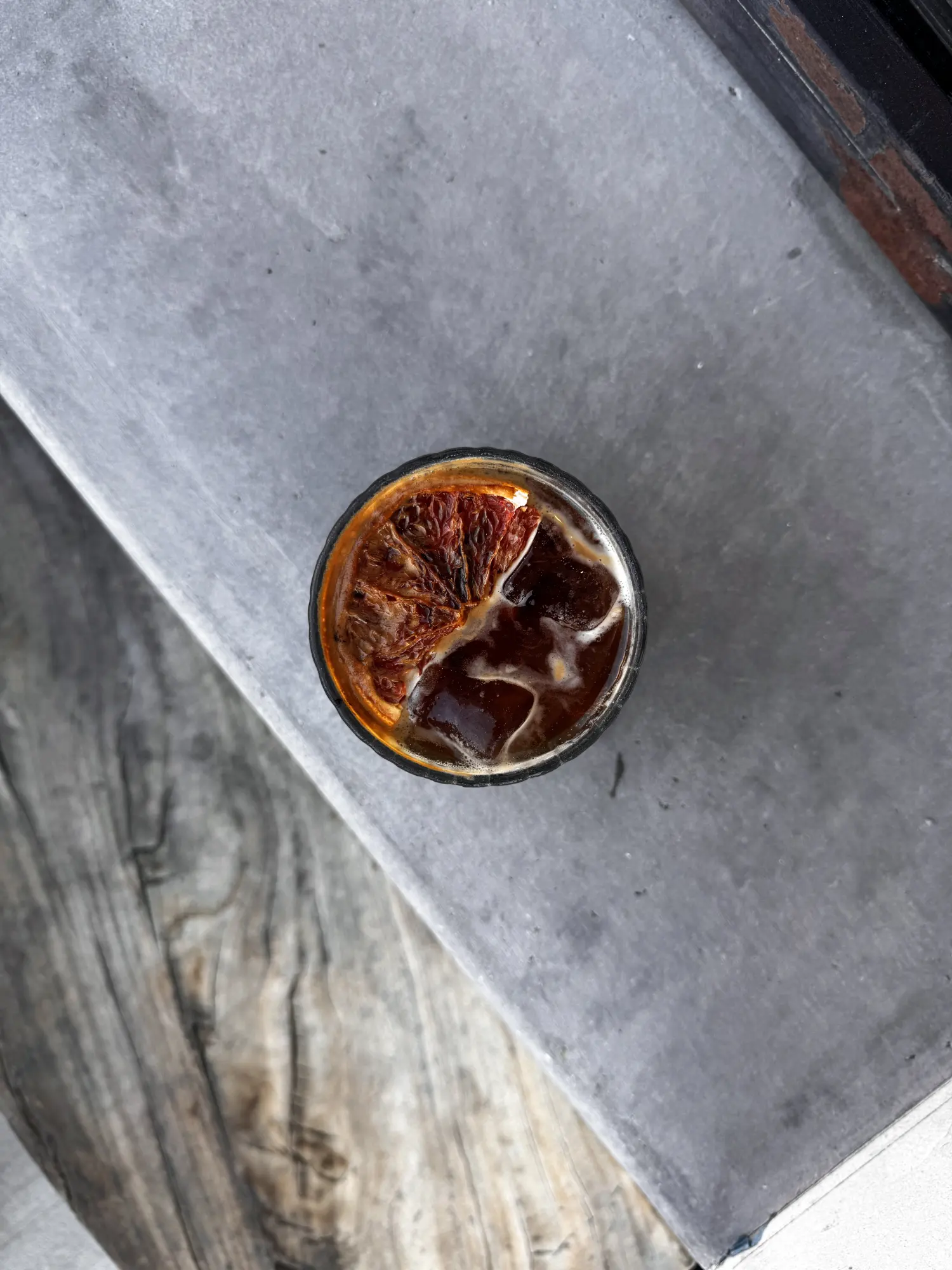 An iced espresso drink on a concrete counter at Concierge Coffee