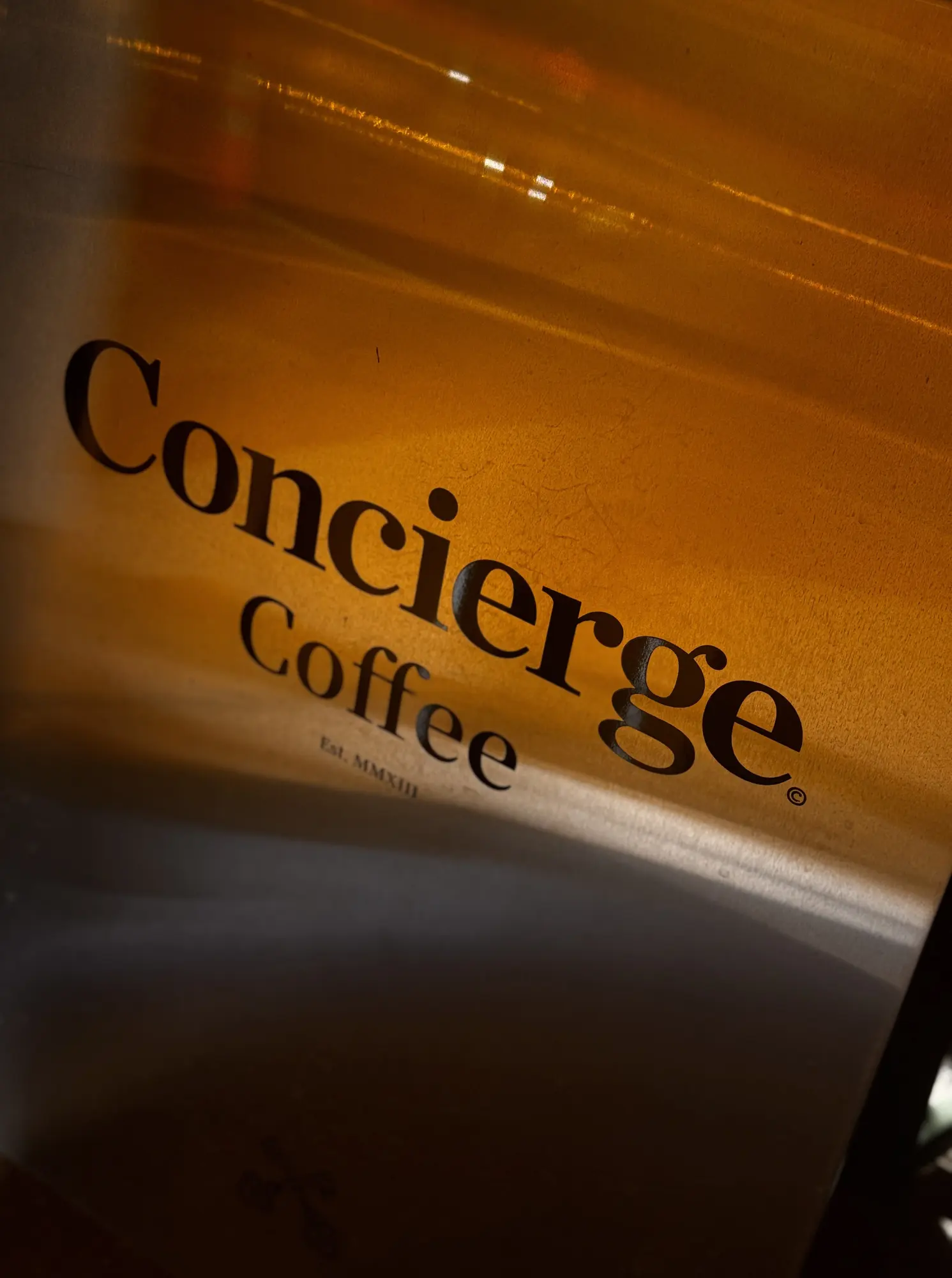 The Concierge Coffee logo in warm light