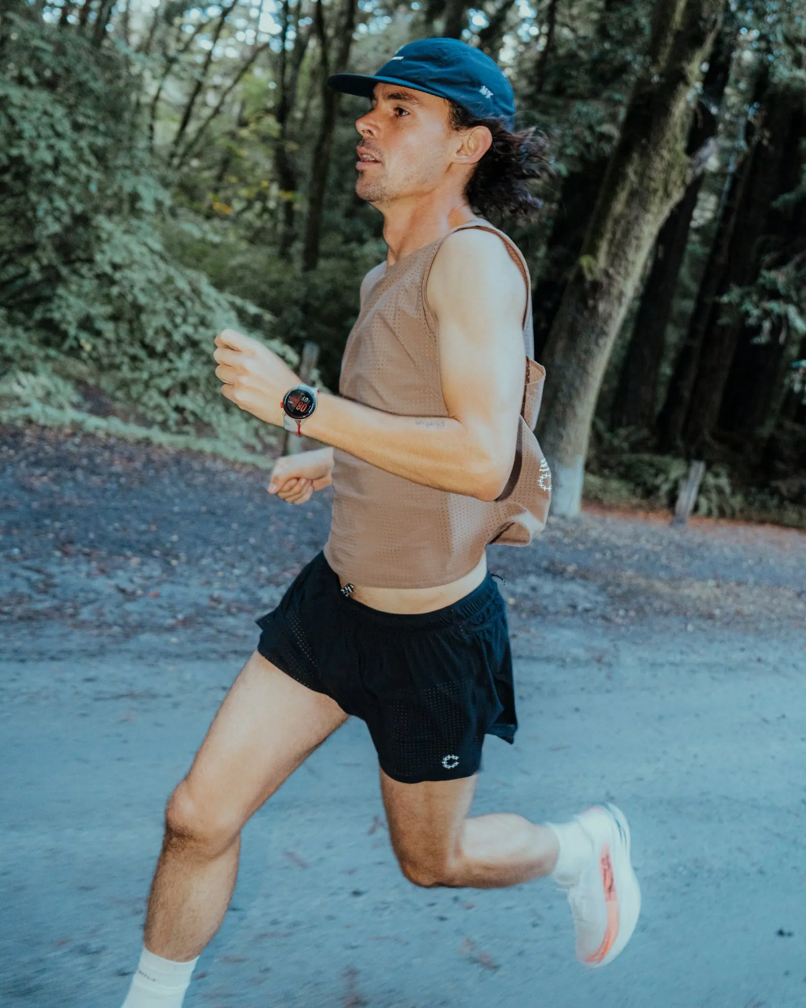 A runner on a forest road in Currently Running kit
